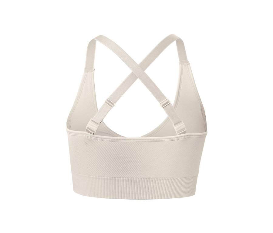 Detail krémově bílé bezešvé sportovní podprsenky zezadu, s překříženými ramínky.
