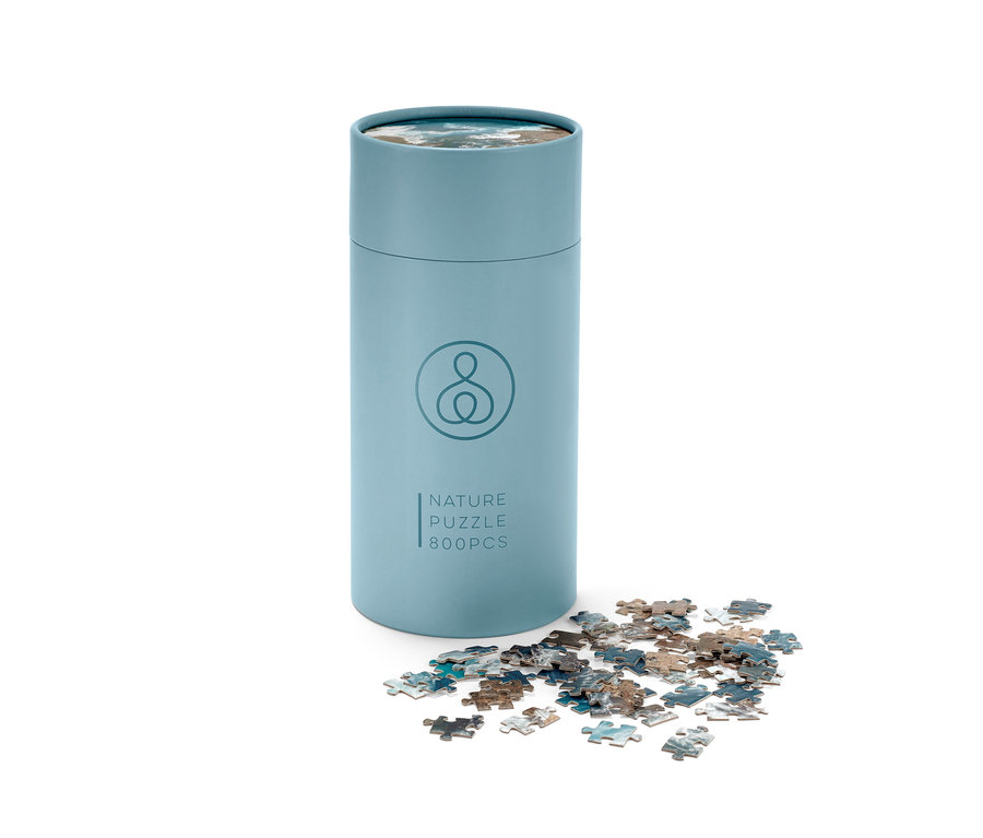 Modrá tuba puzzle »Oceán« s několika dílky rozházenými vedle ní.