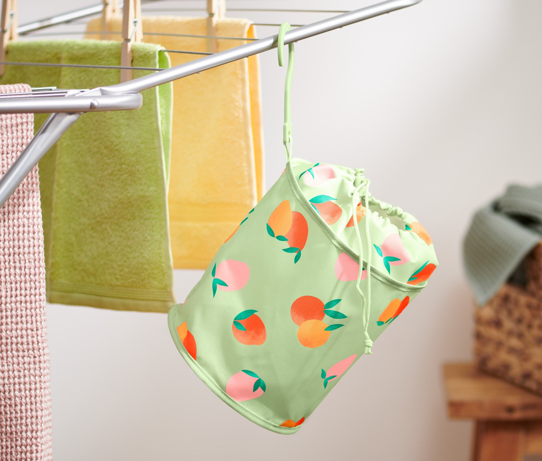 Sáček na kolíčky na prádlo visí na sušáku s ručníky.