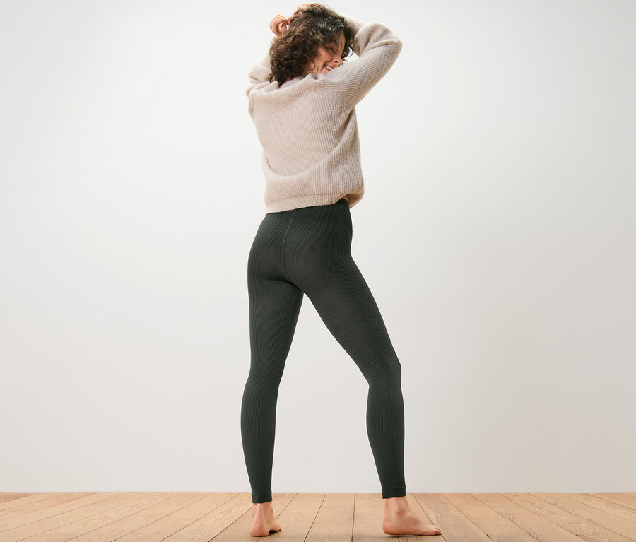 Žena stojí zády k fotoaparátu a má na sobě žebrované termolegíny.