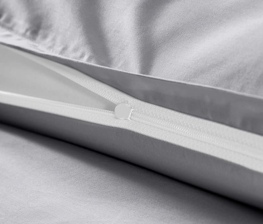 Detail šedého povlečení z bavlněného saténu se zipem.