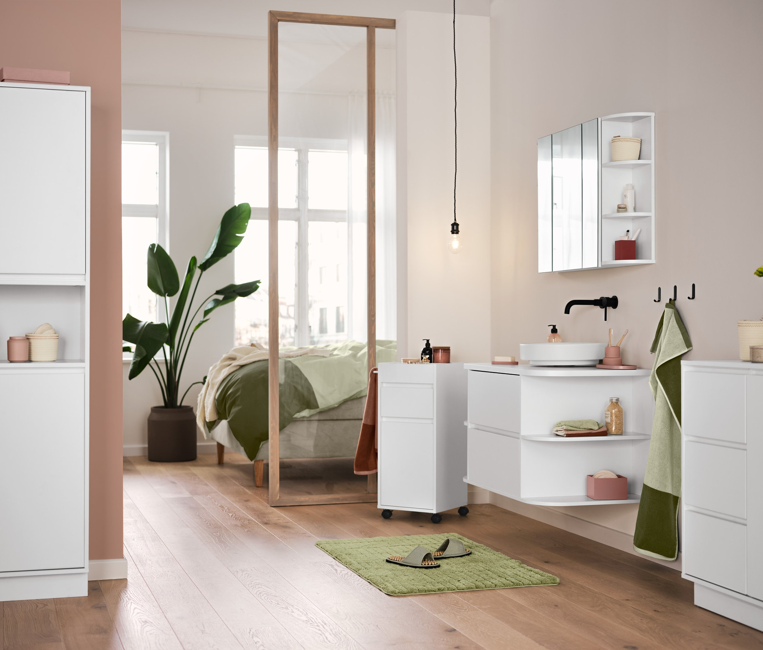 V koupelně stojí bílý koupelnový nábytek, zelená předložka Comfort a visí kvalitní žakárové ručníky v pískově a mechově zelené barvě.