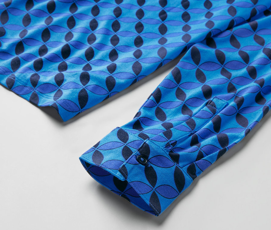 Detail of a blue patterned shirt with a buttoned cuff. Halenkové triko s knoflíkovou légou.