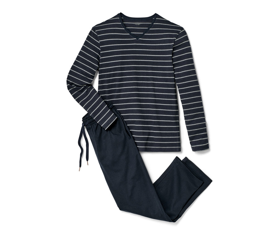 Tmavě modré pyžamo s dlouhým rukávem a pruhovaným topem leží vedle tmavě modrých pyžamových kalhot.