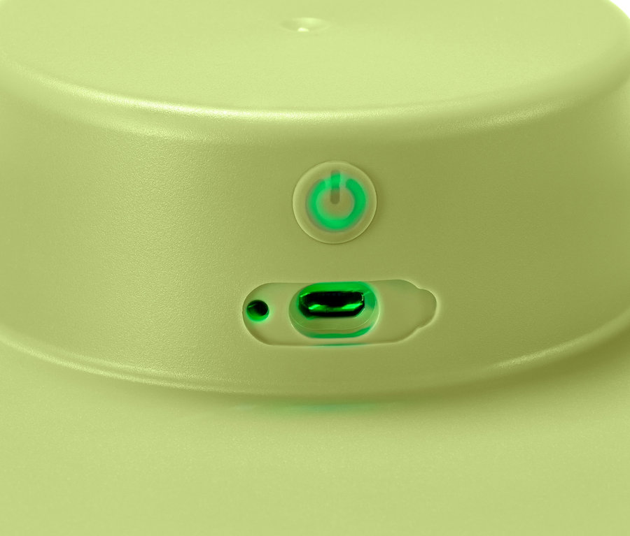 Detail světle zelené bateriové elektrické odstředivky na saláty s tlačítkem napájení a nabíjecím portem.