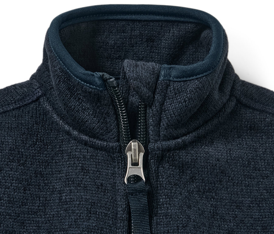 Detail dětské mikiny z pleteného fleecu s rozepnutým zipem.