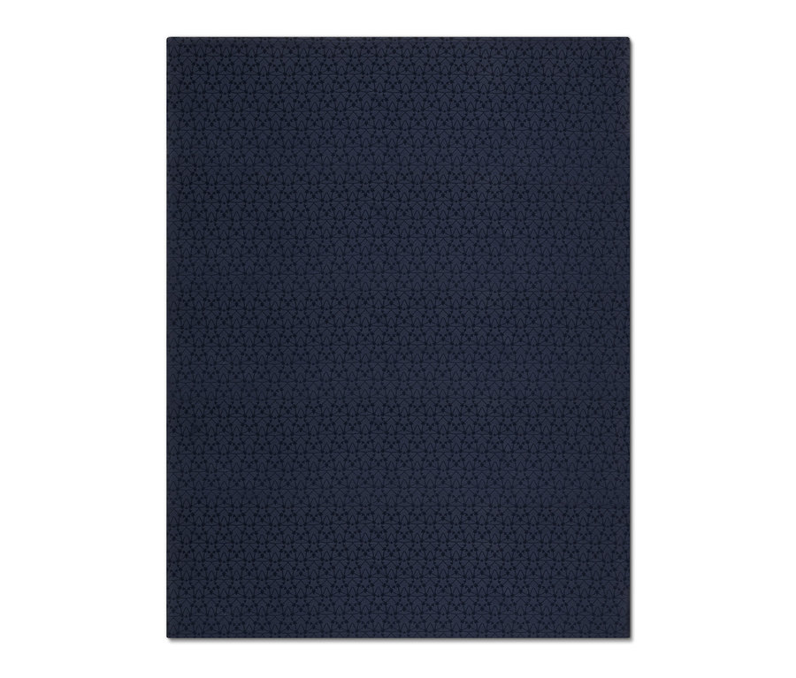 Detailní záběr na tmavě modrý žakárový ubrus s geometrickým vzorem.