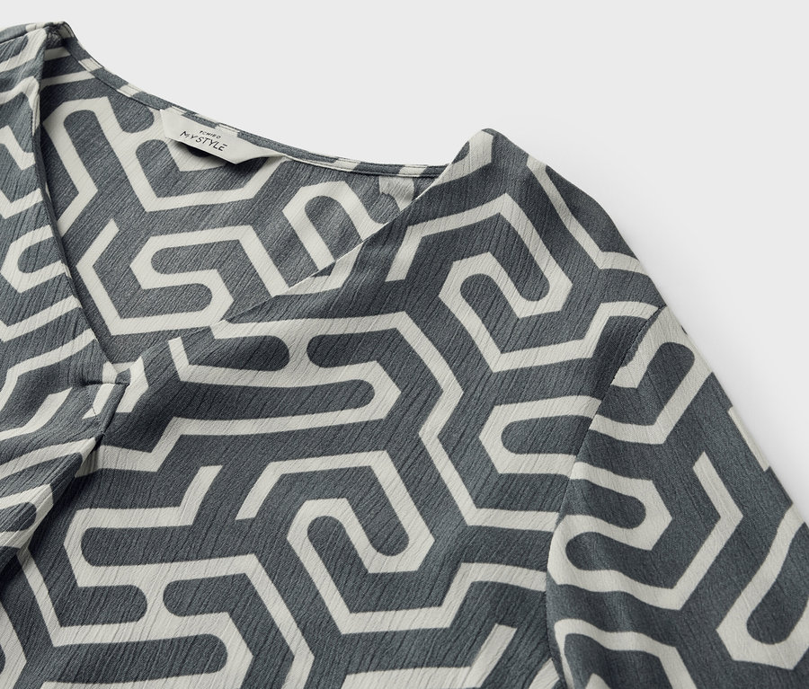 Detail halenky v mačkaném vzhledu s geometrickým vzorem.