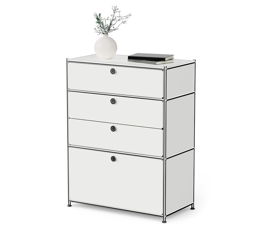 Bílá kovová komoda »CN3« se 3 zásuvkami a 1 výklopnými dvířky. Na komodě stojí váza s rostlinou a kniha.