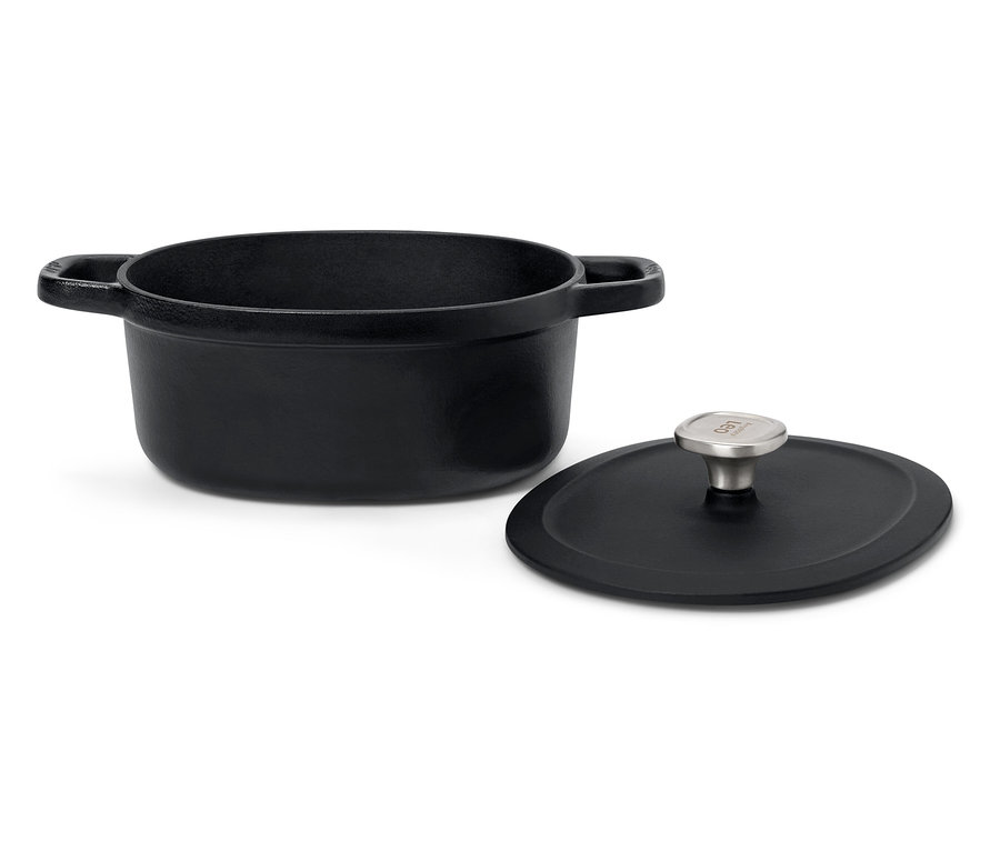 Černý litinový hrnec s poklicí na bílém pozadí.