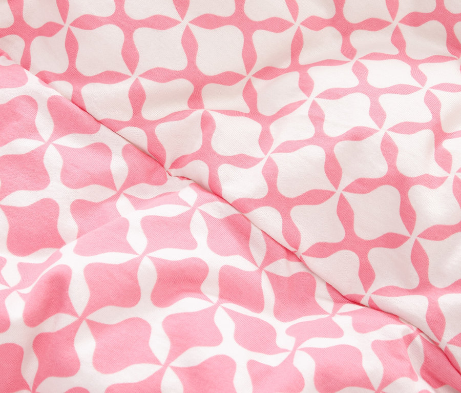 Detail látky s růžovým a bílým geometrickým vzorem.