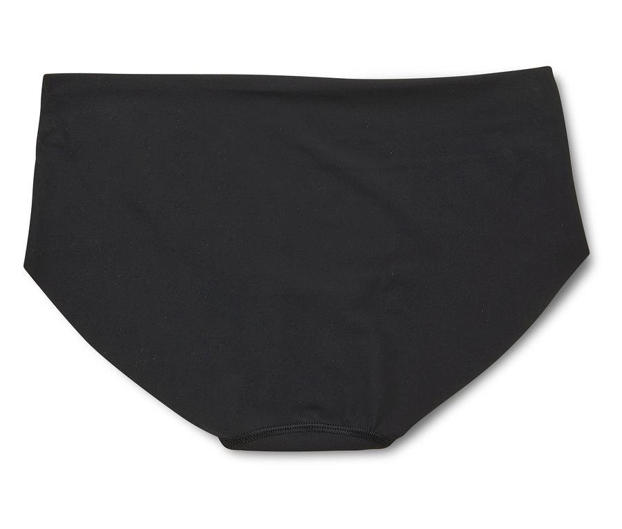 Černé bikiny kalhotky leží na bílém pozadí.
