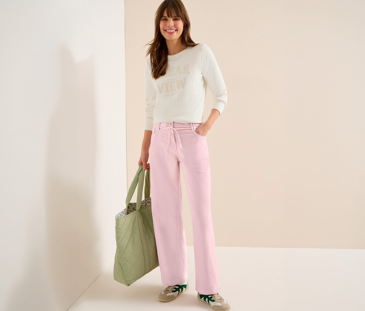 Žena s taškou má na sobě světlý top a růžové džíny CECIL »Neele«.