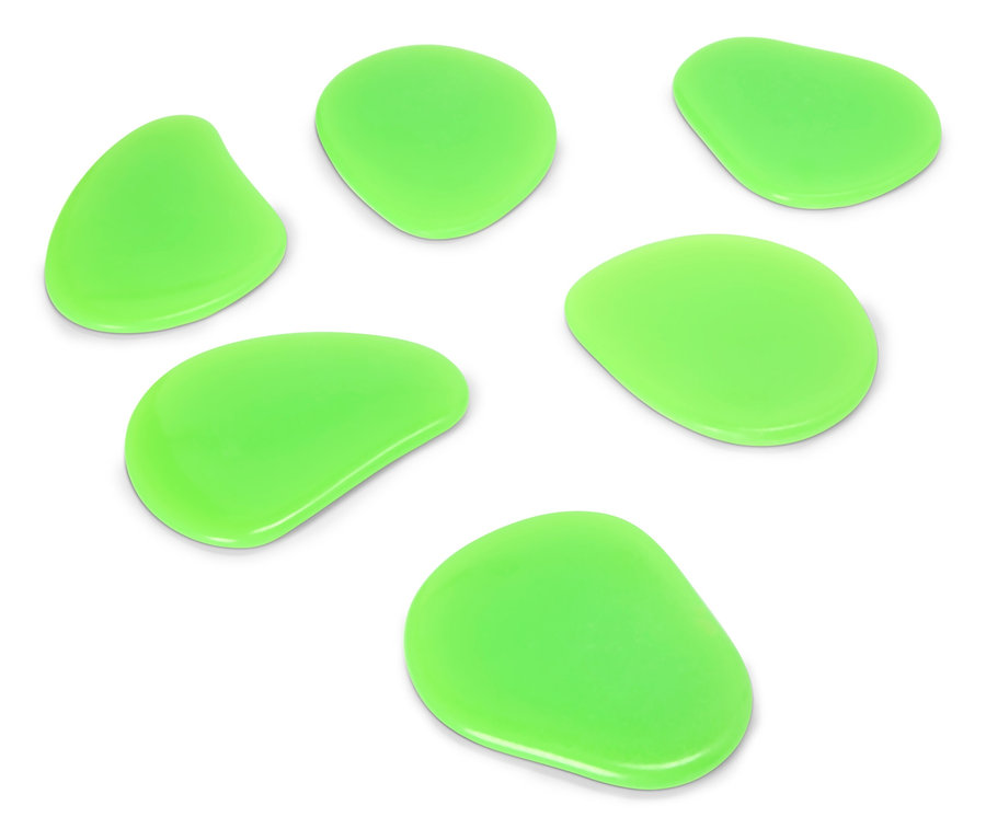 Sedm zelených, nepravidelně tvarovaných kamenů leží na bílém povrchu.