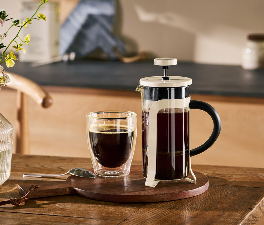 Béžová french press konvička 300 ml a šálek kávy na dřevěném stole.