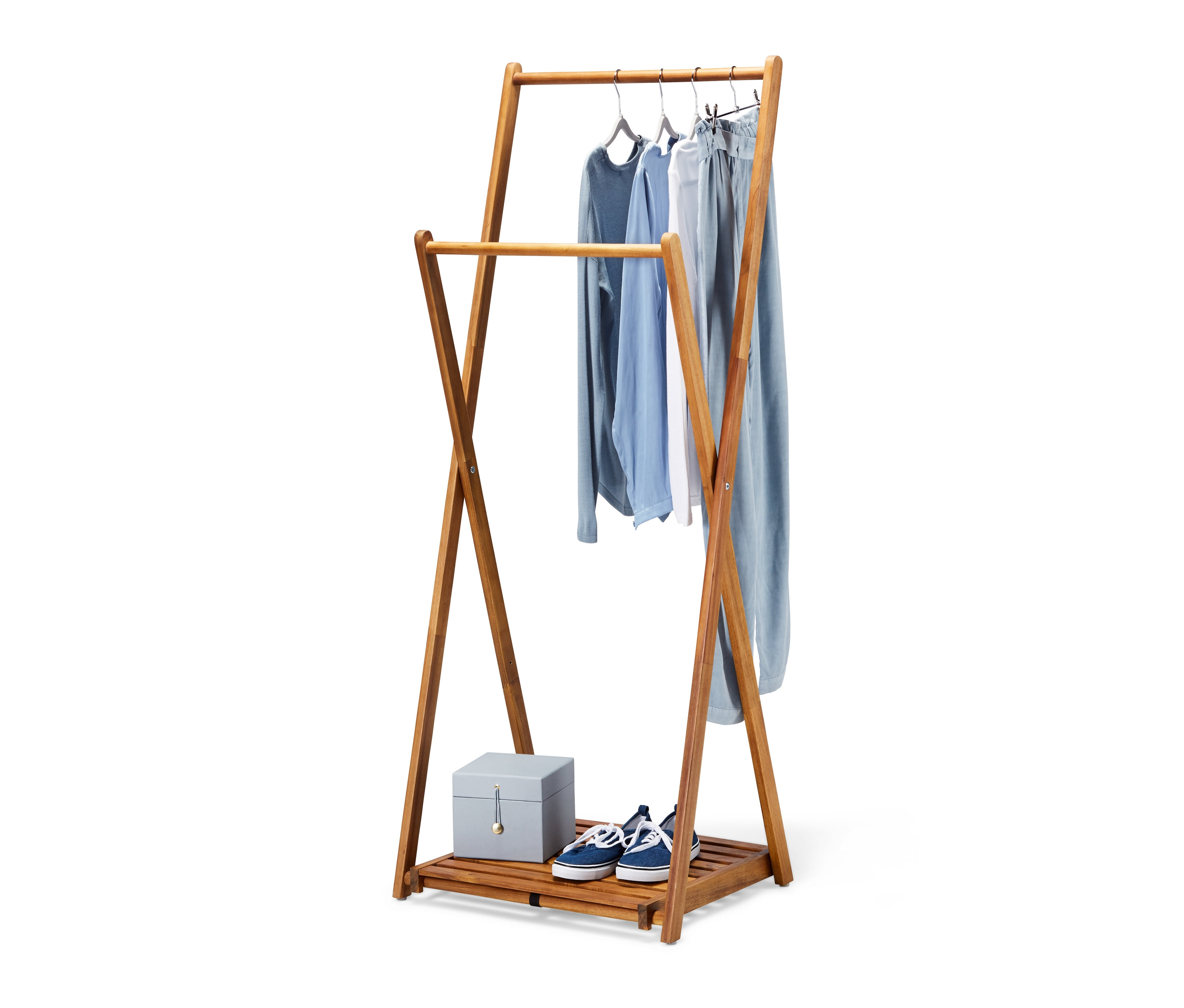 Skládací stojan na oblečení s oblečením, botami a krabicí.