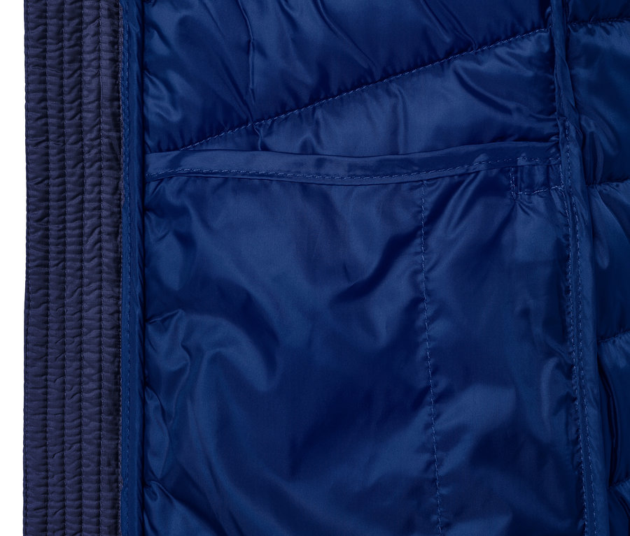 Detail modré prošívané bundy s kapsou.