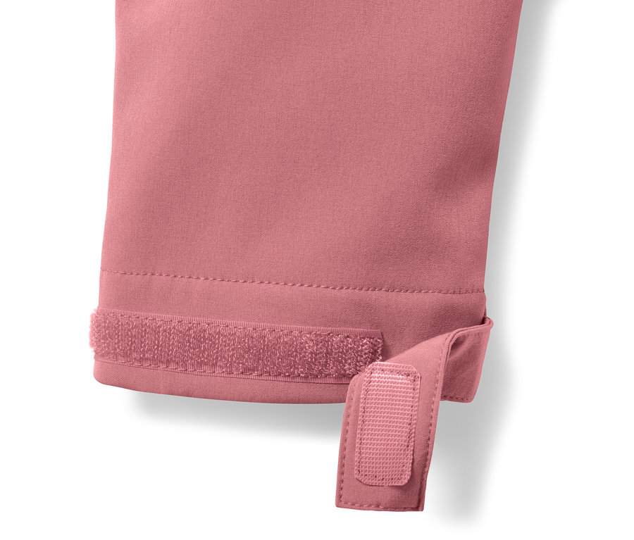 Detail růžového softshellového kabátu se suchým zipem na rukávu.