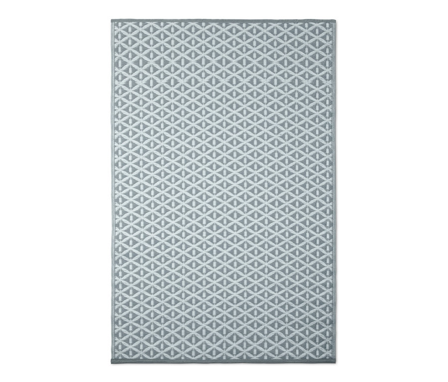 Šedý venkovní koberec s geometrickým vzorem.