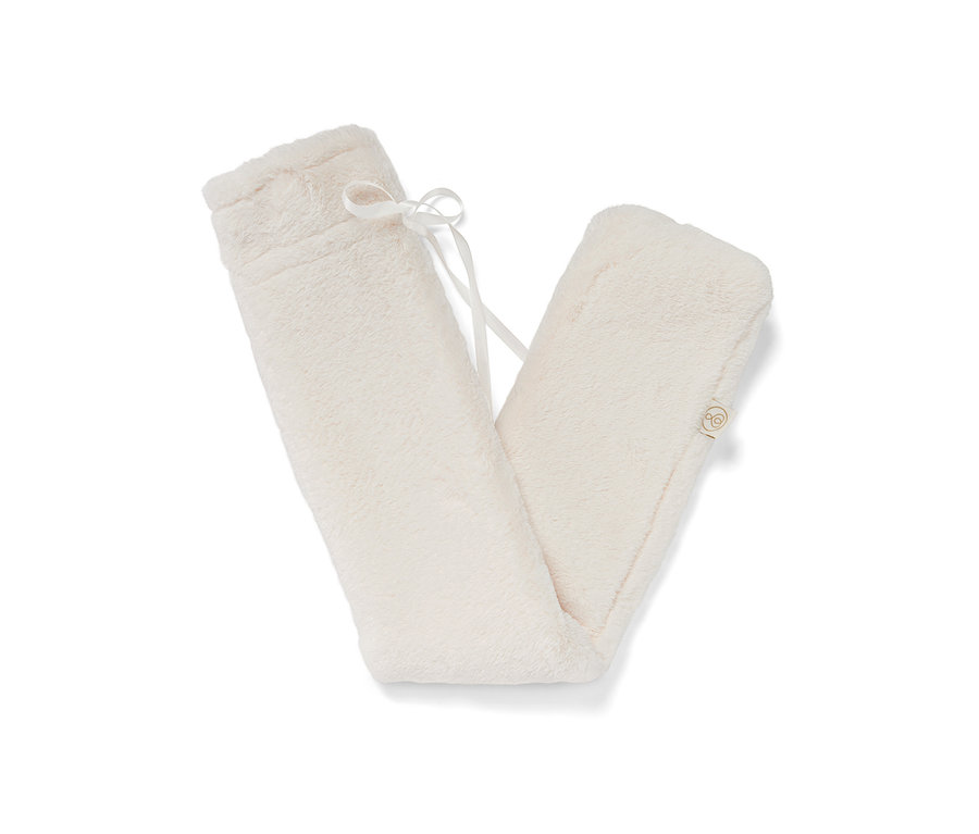 Dlouhý termofor v krémové barvě s plyšovým obalem a bílou stuhou.