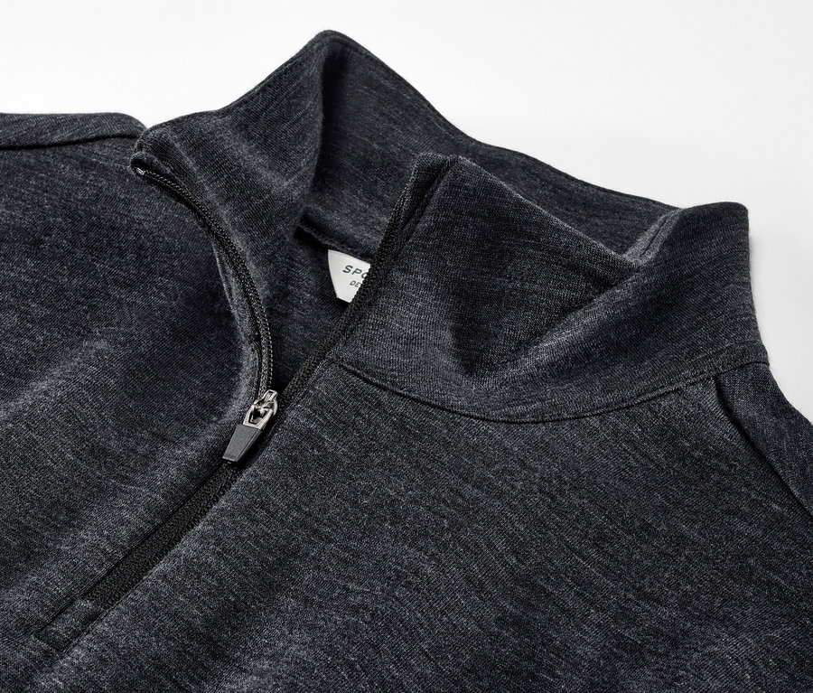 Detailní pohled na funkční triko s vlnou s certifikací RWS s částečně rozepnutým zipem.