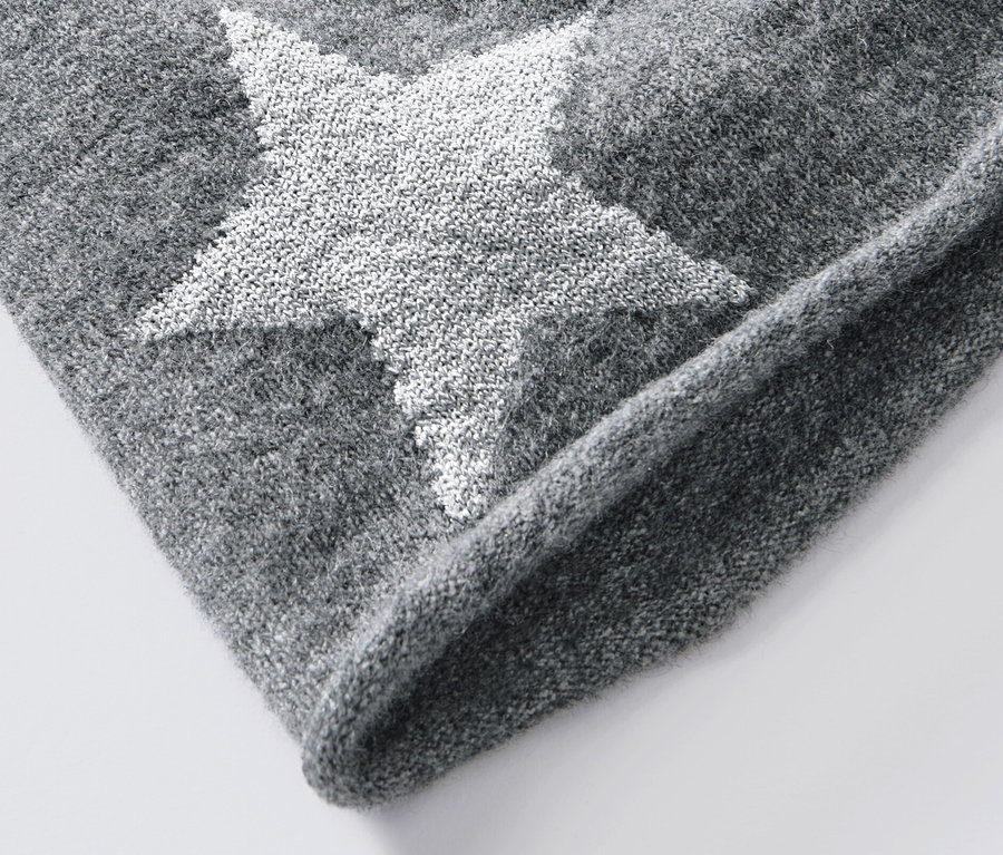 Detail šedé pletené čepice beanie s třpytivou hvězdou.