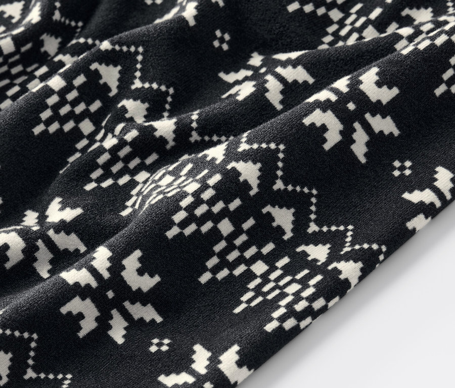 Detailní záběr na černé legíny s norským vzorem.