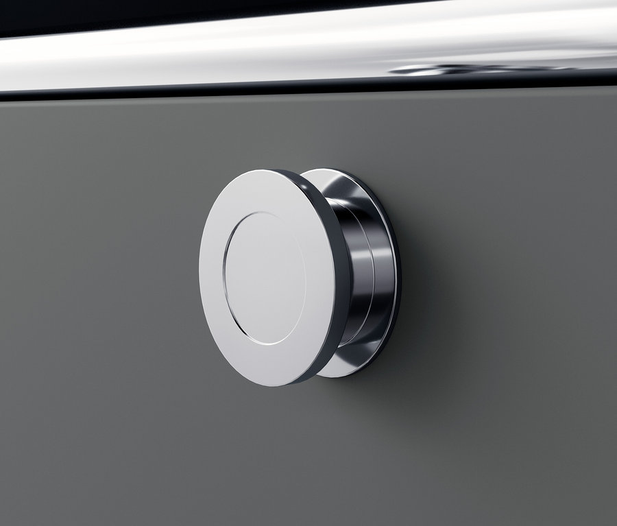 Detail šedé kovové komody »CN3« s kulatou stříbrnou úchytkou.