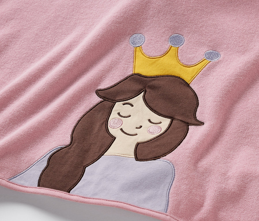 Detail růžového froté ponča s aplikací princezny s hnědými vlasy a zlatou korunou.