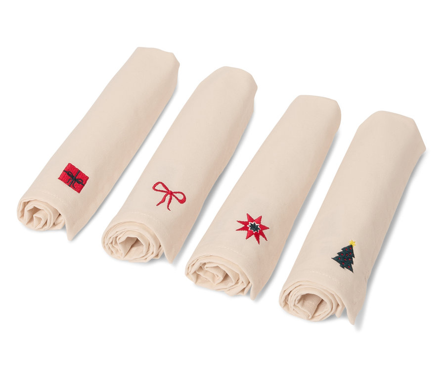 Čtyři stočené béžové ubrousky s vánočními motivy.