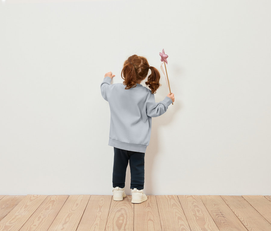 Dívka v modré mikině drží hůlku s hvězdou.