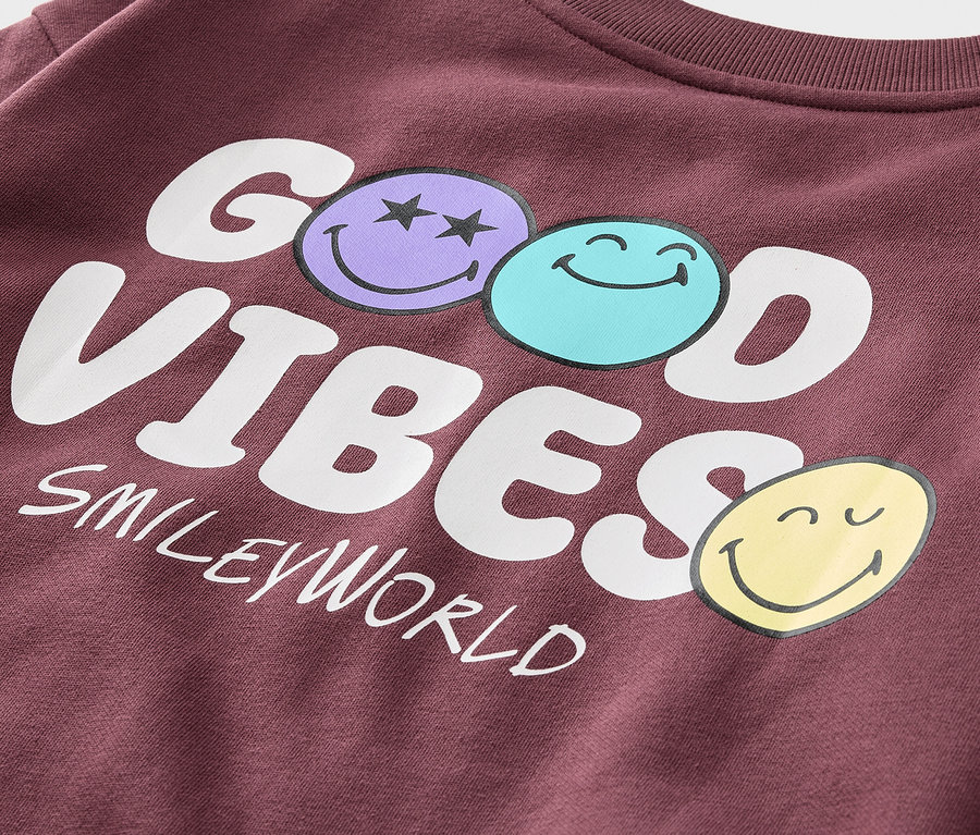 Detail bordó mikiny s nápisem GOOD VIBES SMILEYWORLD a třemi smajlíky.