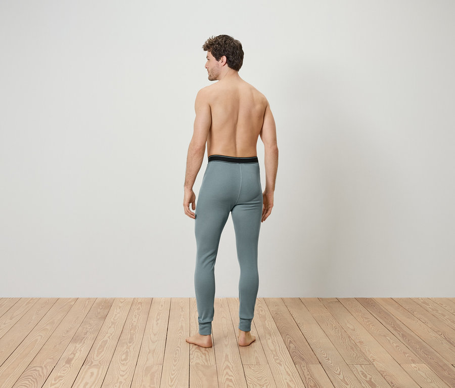 Muž zády k fotoaparátu má na sobě šedé termoprádlo.