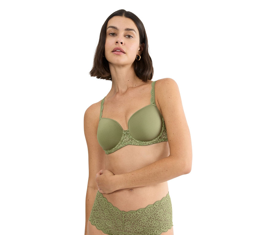 Žena má na sobě olivově zelenou podprsenku s krajkovým lemem a odpovídající spodní prádlo.