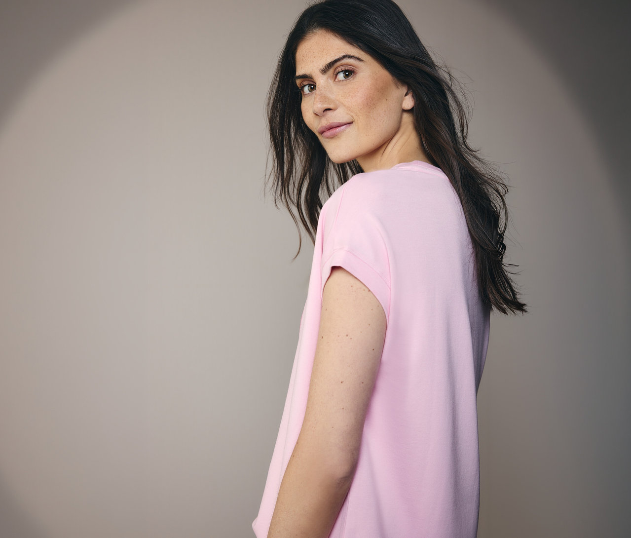 Žena se dívá přes rameno a má na sobě tričko Placement CECIL.