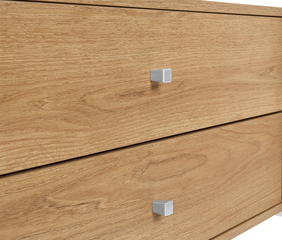 Detailní záběr na dřevěnou skříňku se dvěma zásuvkami a stříbrnými úchytkami.