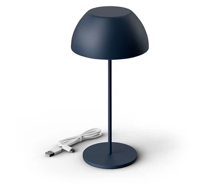 Na bílém pozadí stojí tmavě modrá lampa s USB kabelem.