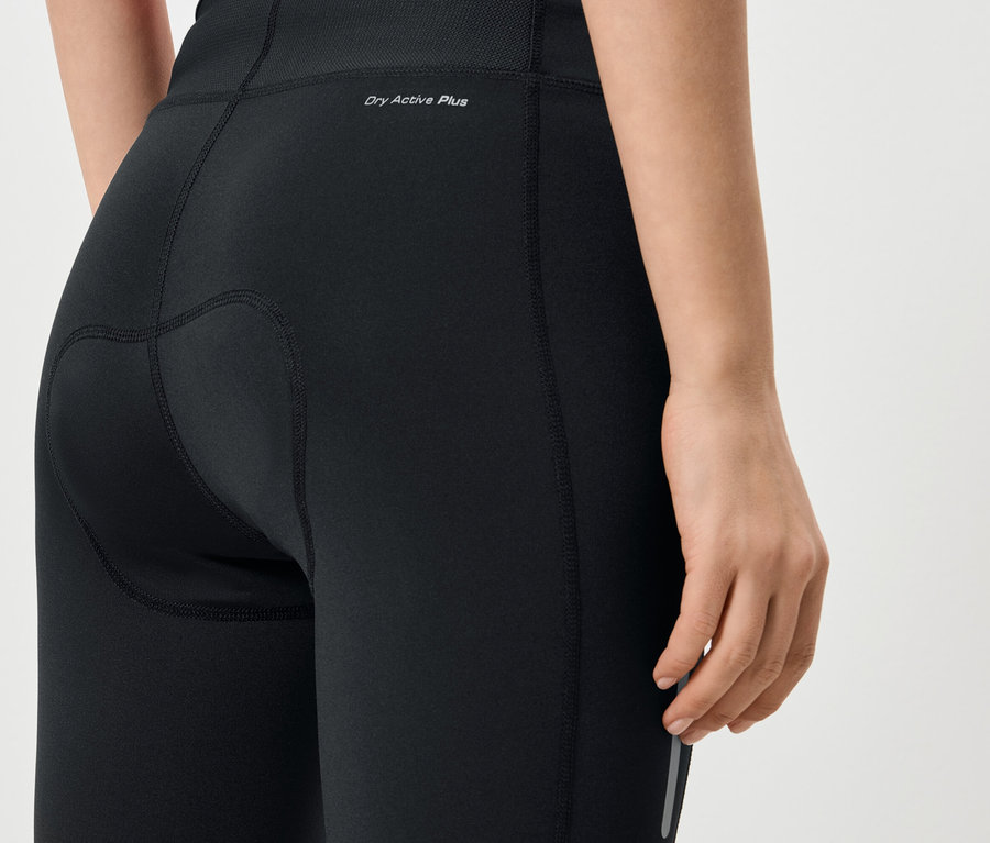 Detailní záběr na zadní část ženy v černých legínách s nápisem „Dry Active Plus“.