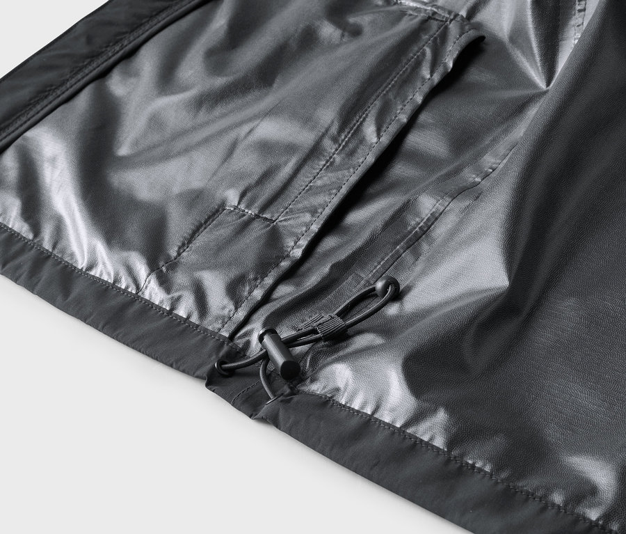 Detailní záběr na vnitřek šedé bundy s kapsou a stahovací šňůrkou.