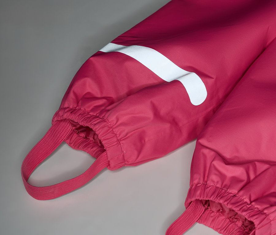 Detail růžových kalhot s bílým pruhem a gumičkami.