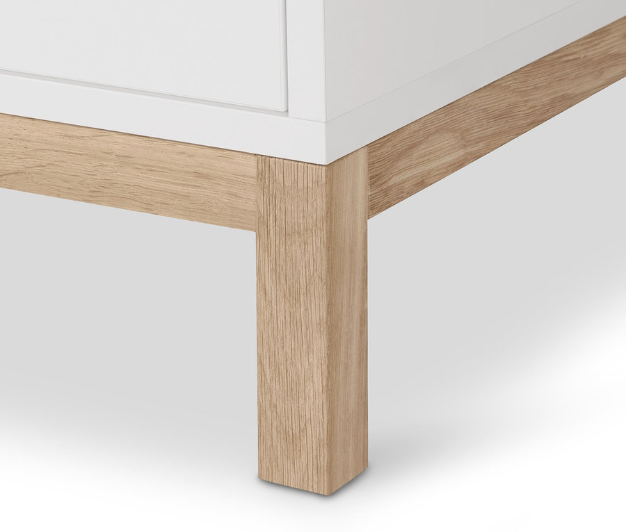 Detail rohu šatní skříně Eklund s dřevěnou nohou.