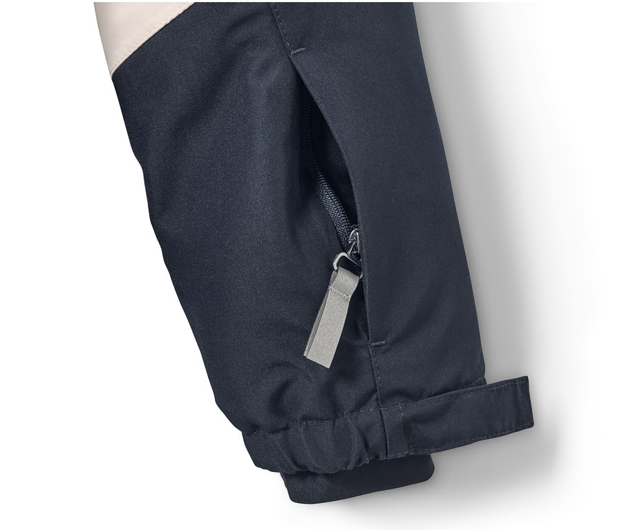 Detail lyžařské bundy s kapsou na zip.