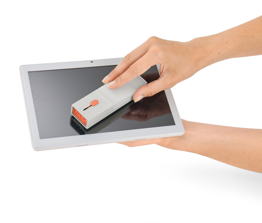 Žena čistí obrazovku tabletu pomocí sady na čištění psacího stolu 4 v 1.