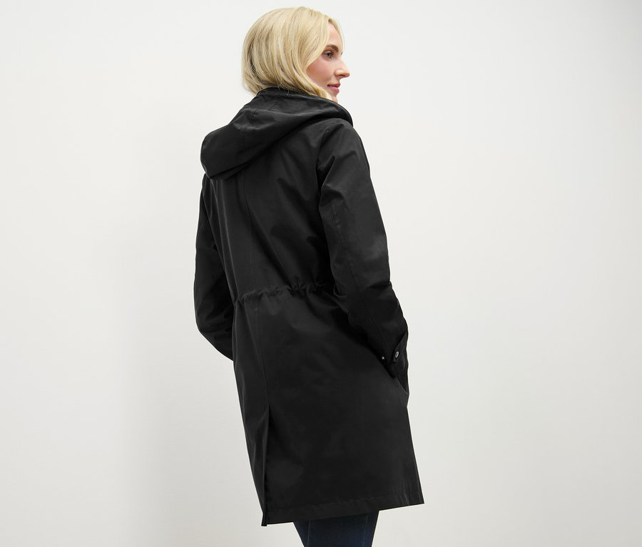 Žena má na sobě černou parku s kapucí.