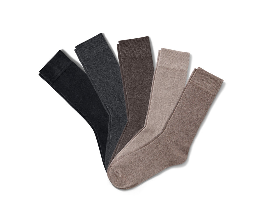 Pět párů ponožek různých barev leží na bílém pozadí.