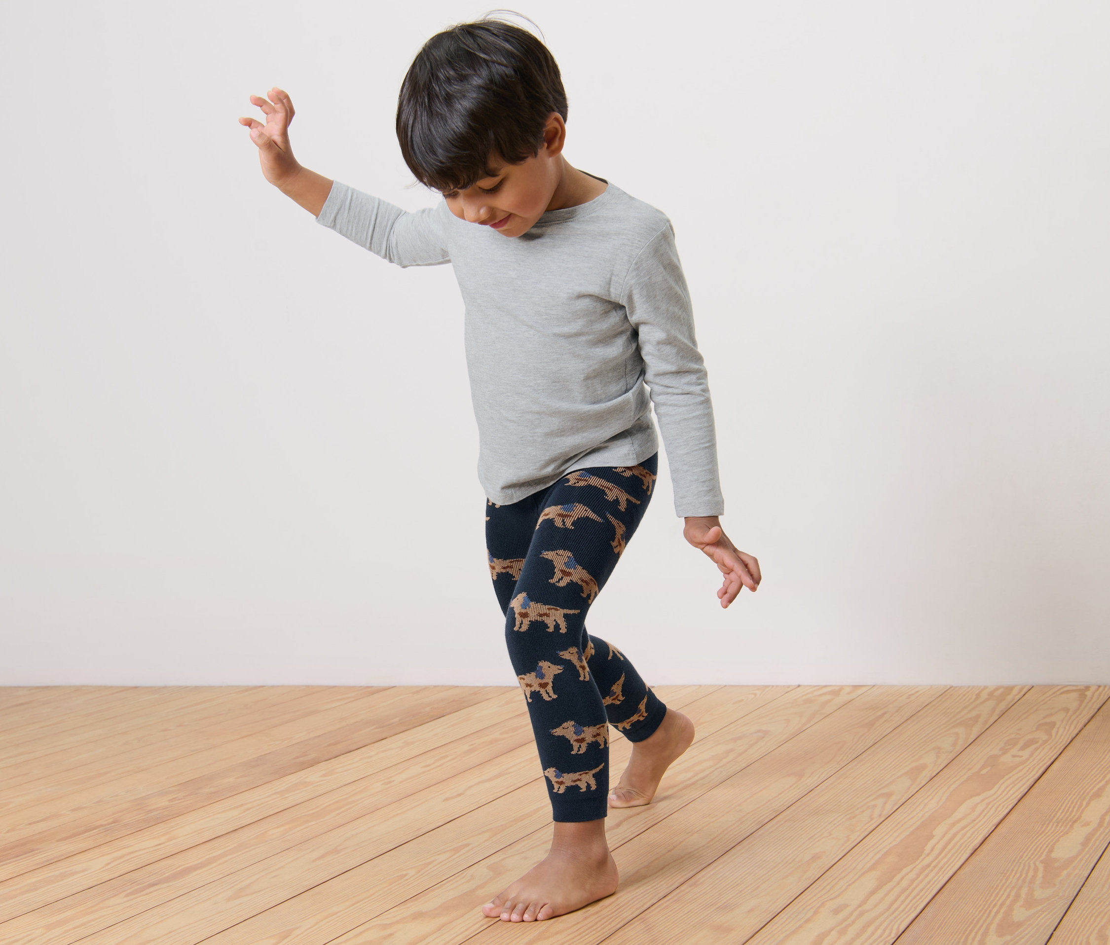 Chlapec tančí v termolegínách s potiskem jezevčíků.