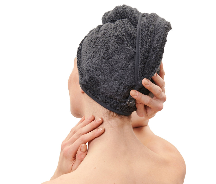 Žena si upravuje antracitový ručníkový turban na hlavě.