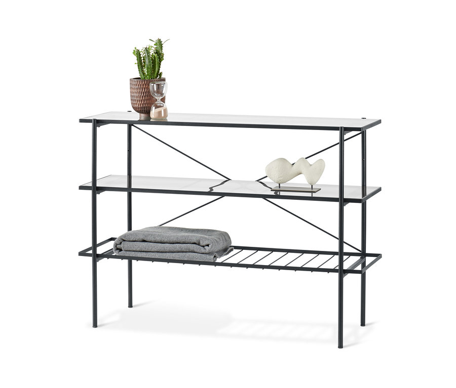 Konzolový stolek šířky cca 120 cm se třemi policemi. Na horní polici je květináč, skleněné hodiny a na druhé polici je dekorace.