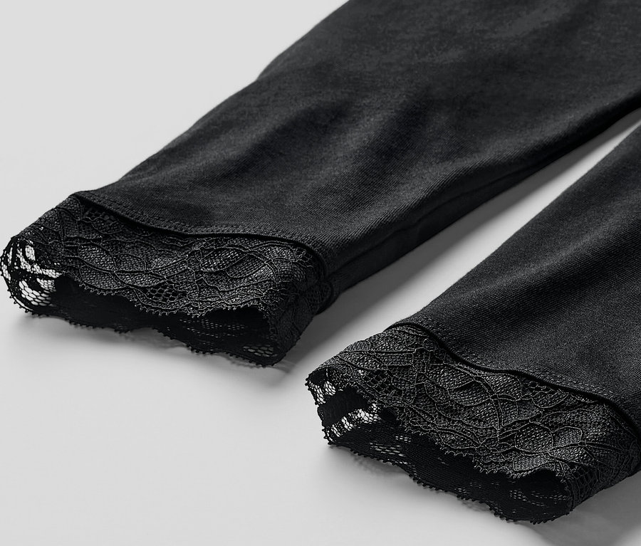 Detail černých legín s krajkovým lemem.