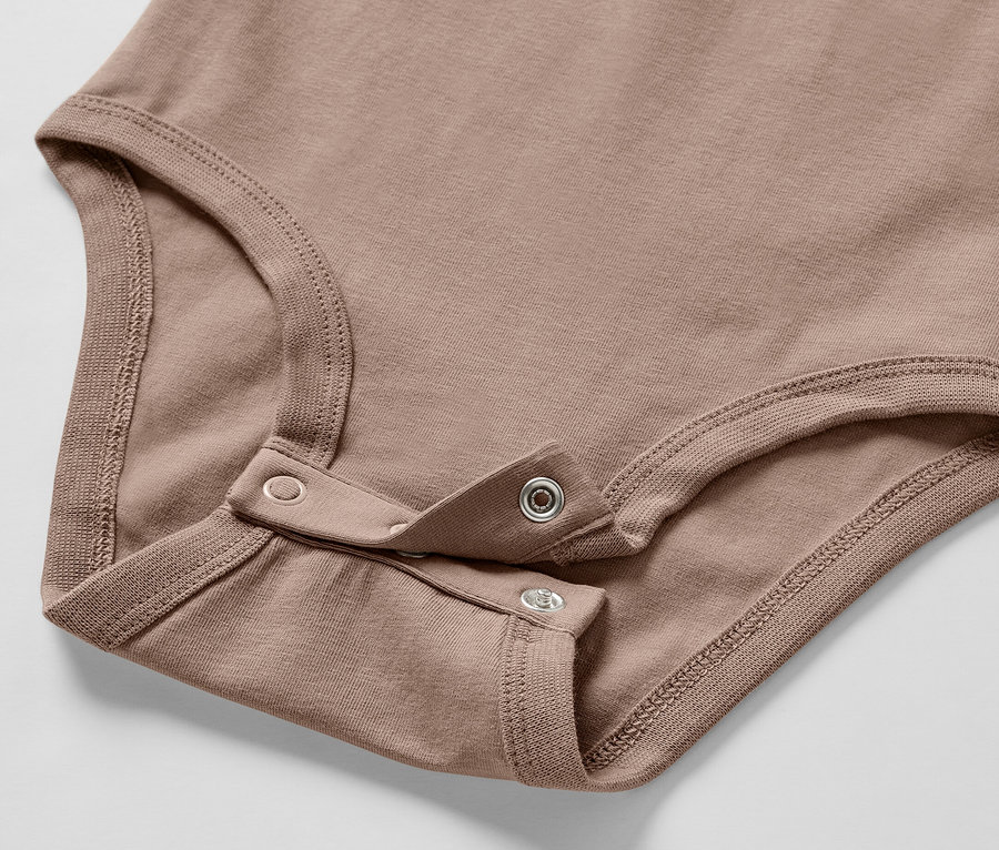 Detail hnědého body pro miminka Souprava pro miminka, se zapínáním na patentky.